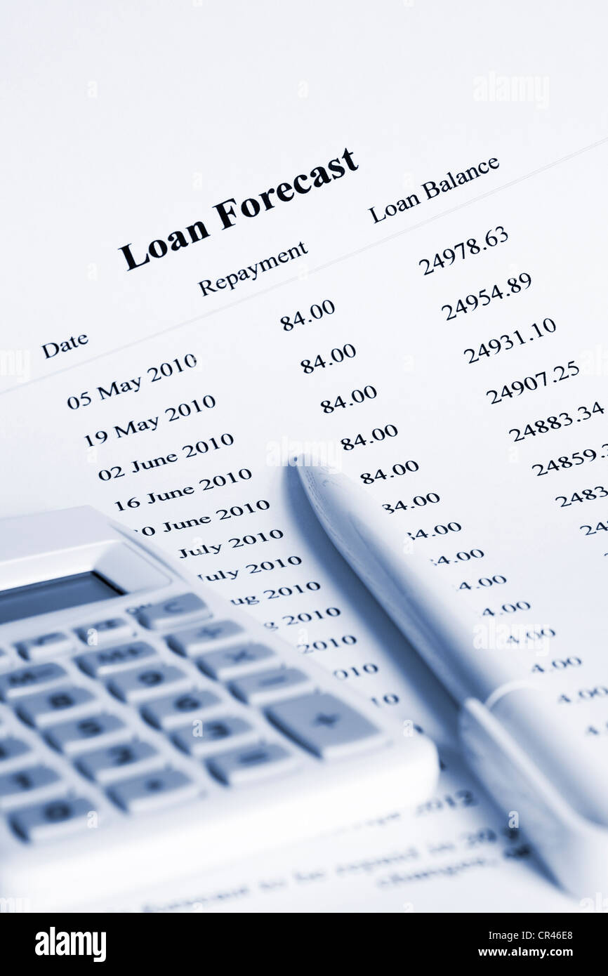 Schedule of payments for loan with calculator and pen, slight blue tone. Stock Photo