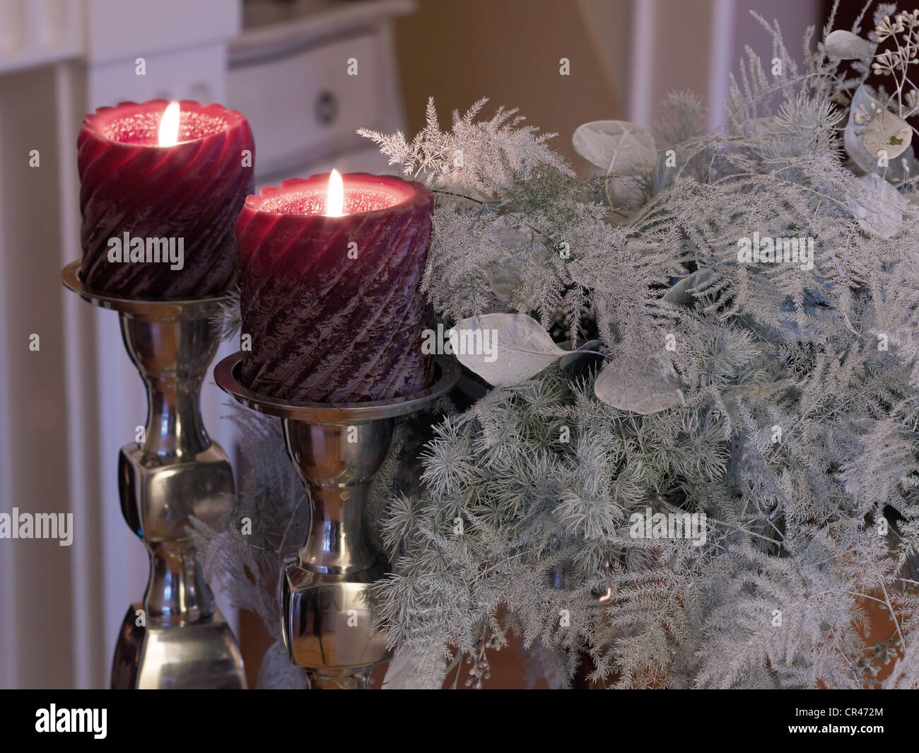 2 candles in noble silver candlesticks in a festive atmosphere Stock Photo