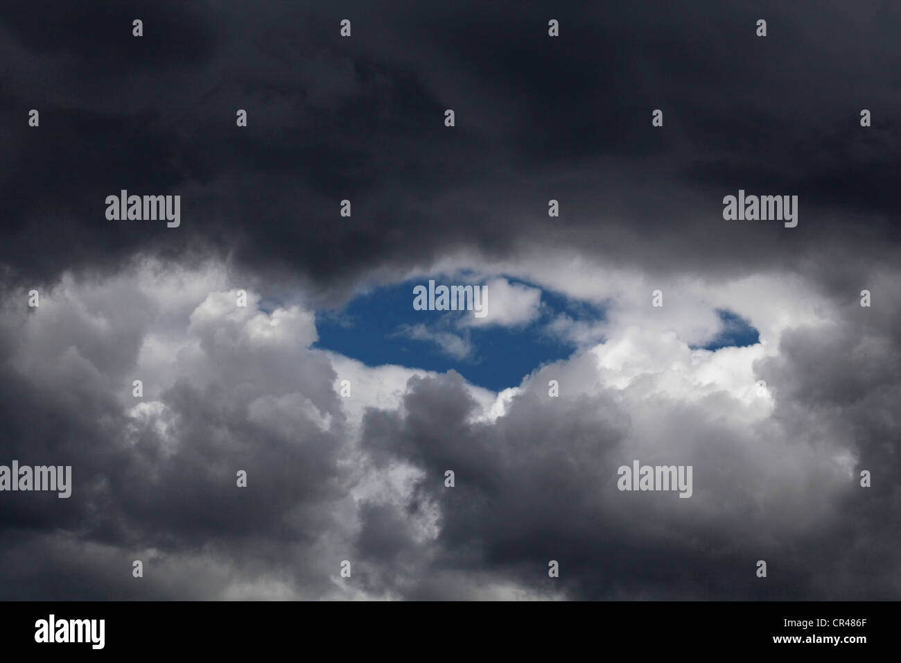A section of the sky with rain threatening clouds fringed with cumulus clouds. Stock Photo