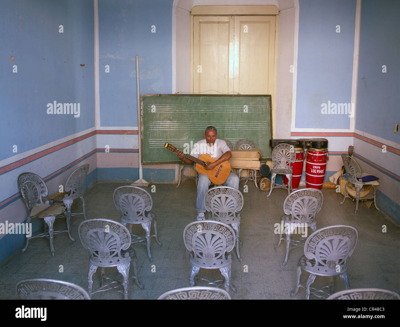 Cuban guitar teacher preparing his music lessons in an empty classroom, Trinidad, Cuba, Latin