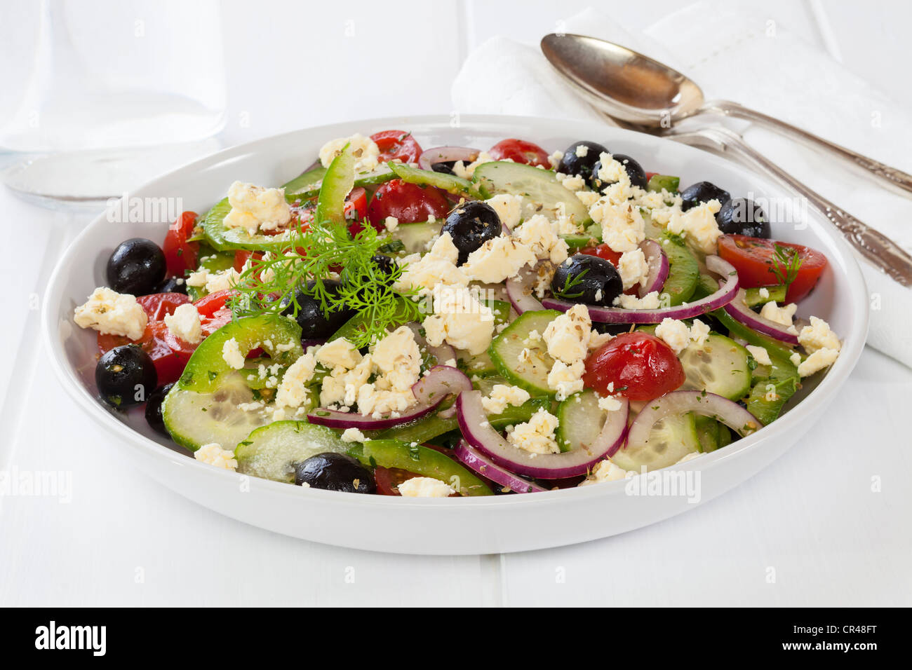 Greek salad, a delicious combination of green capsicum, black olives, cucumber, tomato, red onion, mint, dill and oregano, Stock Photo