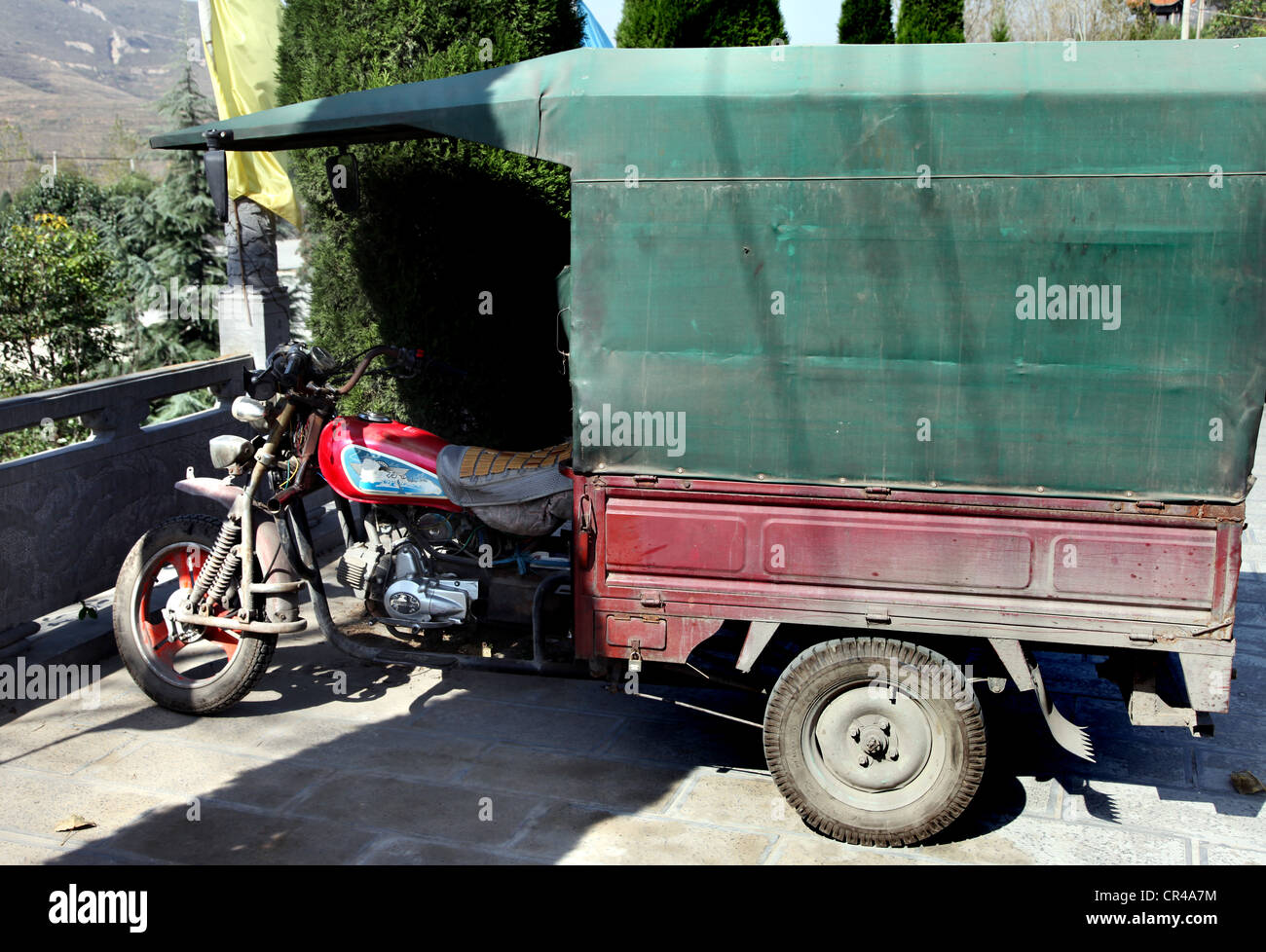 It's a photo of a small van with the front of a motorcycle or motorbike. It's typical in china and convenient to use for people Stock Photo
