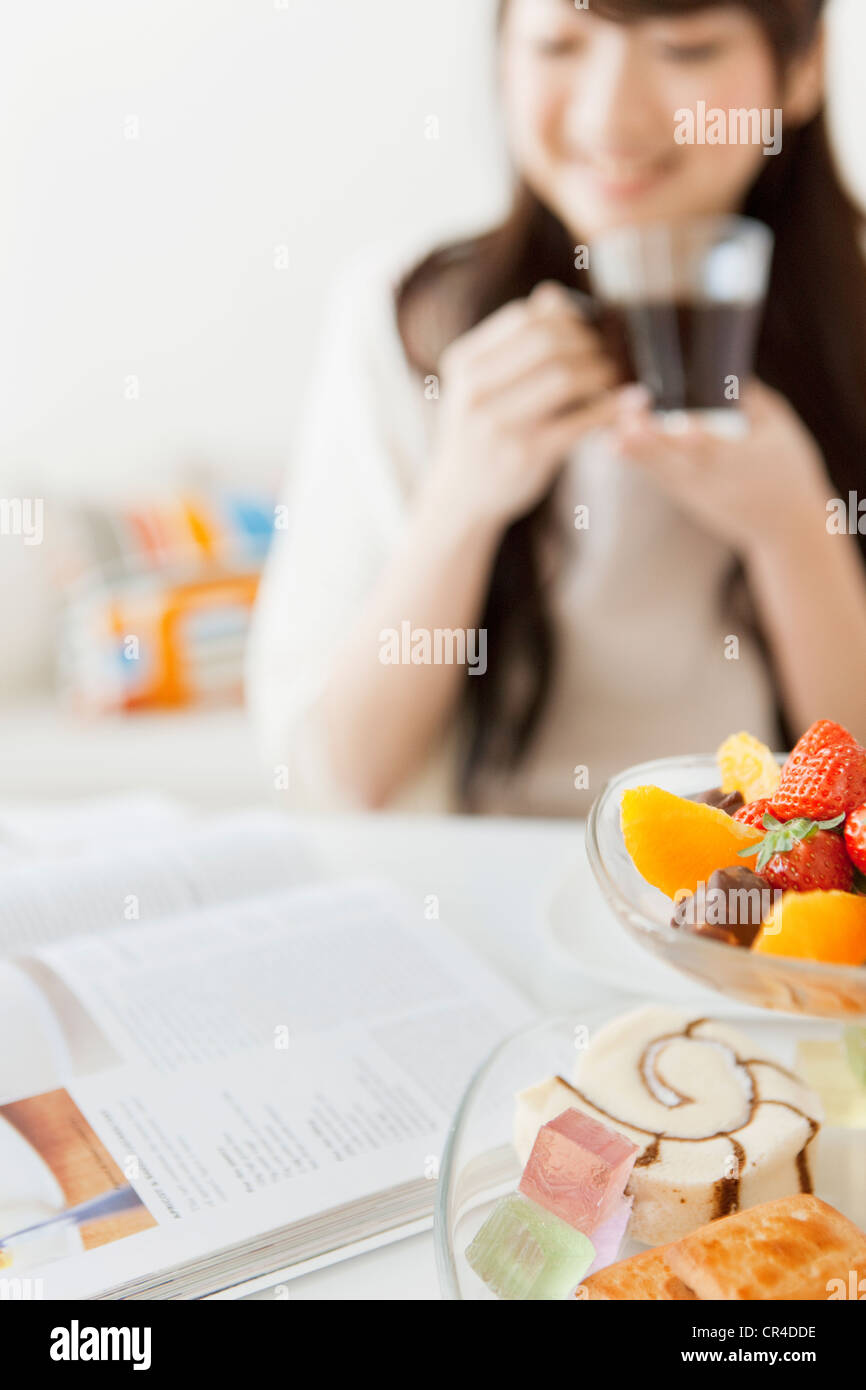 Young Woman Having Tea and Reading Magazines Stock Photo