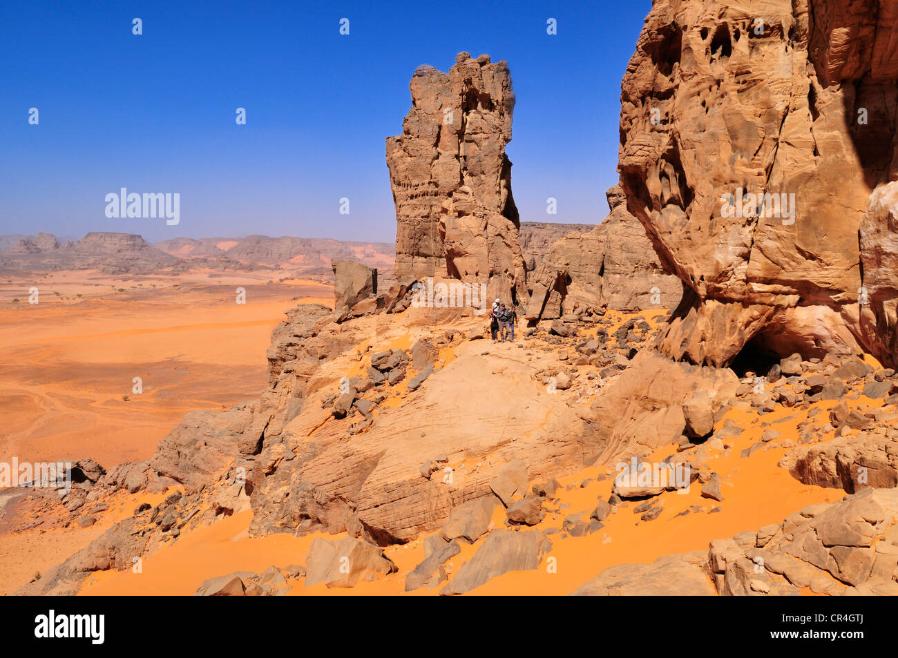 People hiking in a sandstone rock formation, Tadrart, Tassili n'Ajjer ...