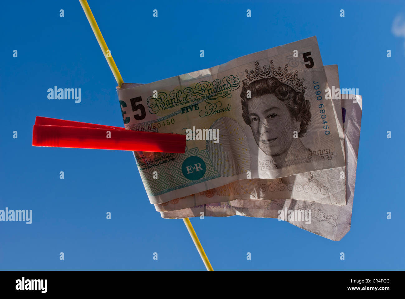 Washing Line Notes looking up at a five pound note on a washing line held with red washing ...