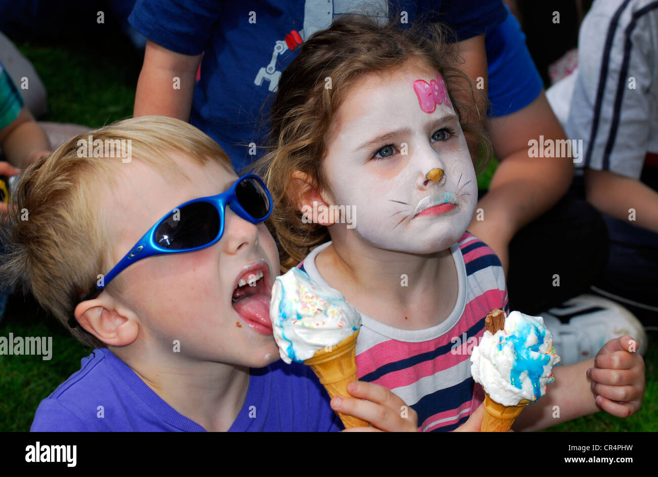 Youngsters enthralled by Punch & Judy show and eating ice cream at a
