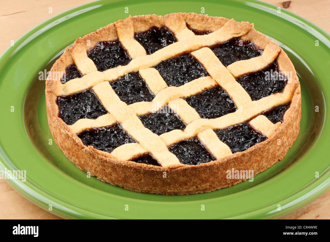 Homemade cherry jam tart on a green dish over a wooden background Stock Photo
