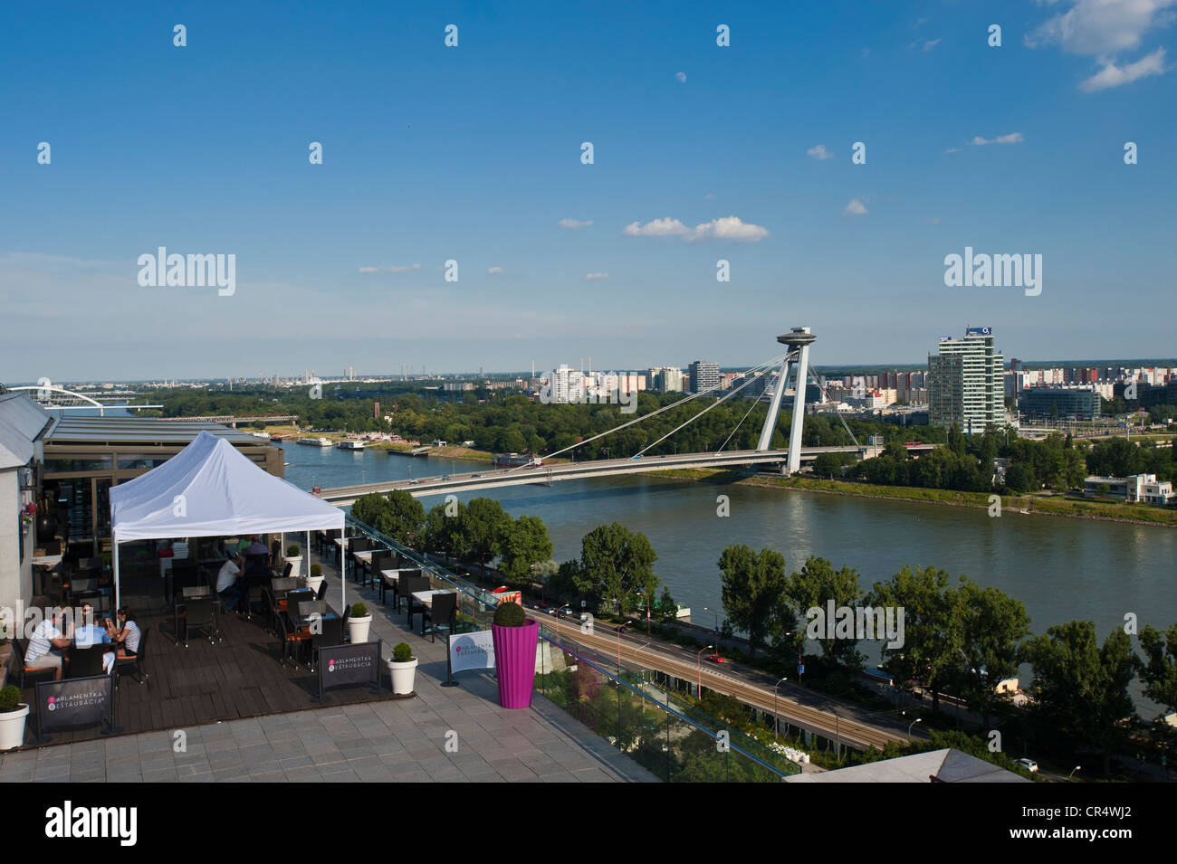 Novy Most, New Bridge crossing the Danube River with a cafe terrace in front of Parliament House, Bratislava, Slovakia, Europe Stock Photo