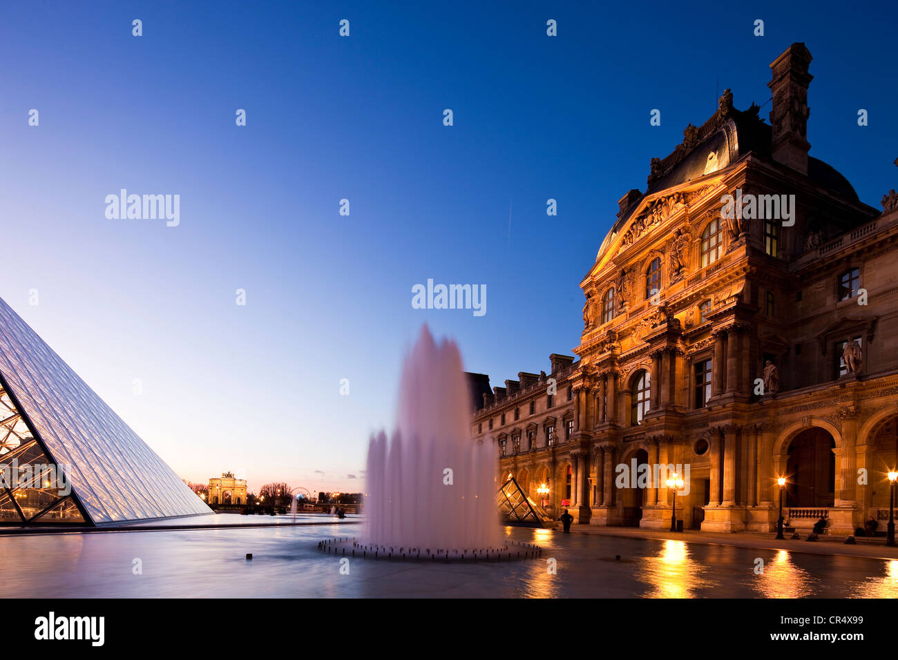 France, Paris, Louvre Museum and Pyramid by the architect Ieoh Ming Pei in the Cour Napoleon, lighting by Claude Engle Stock Photo
