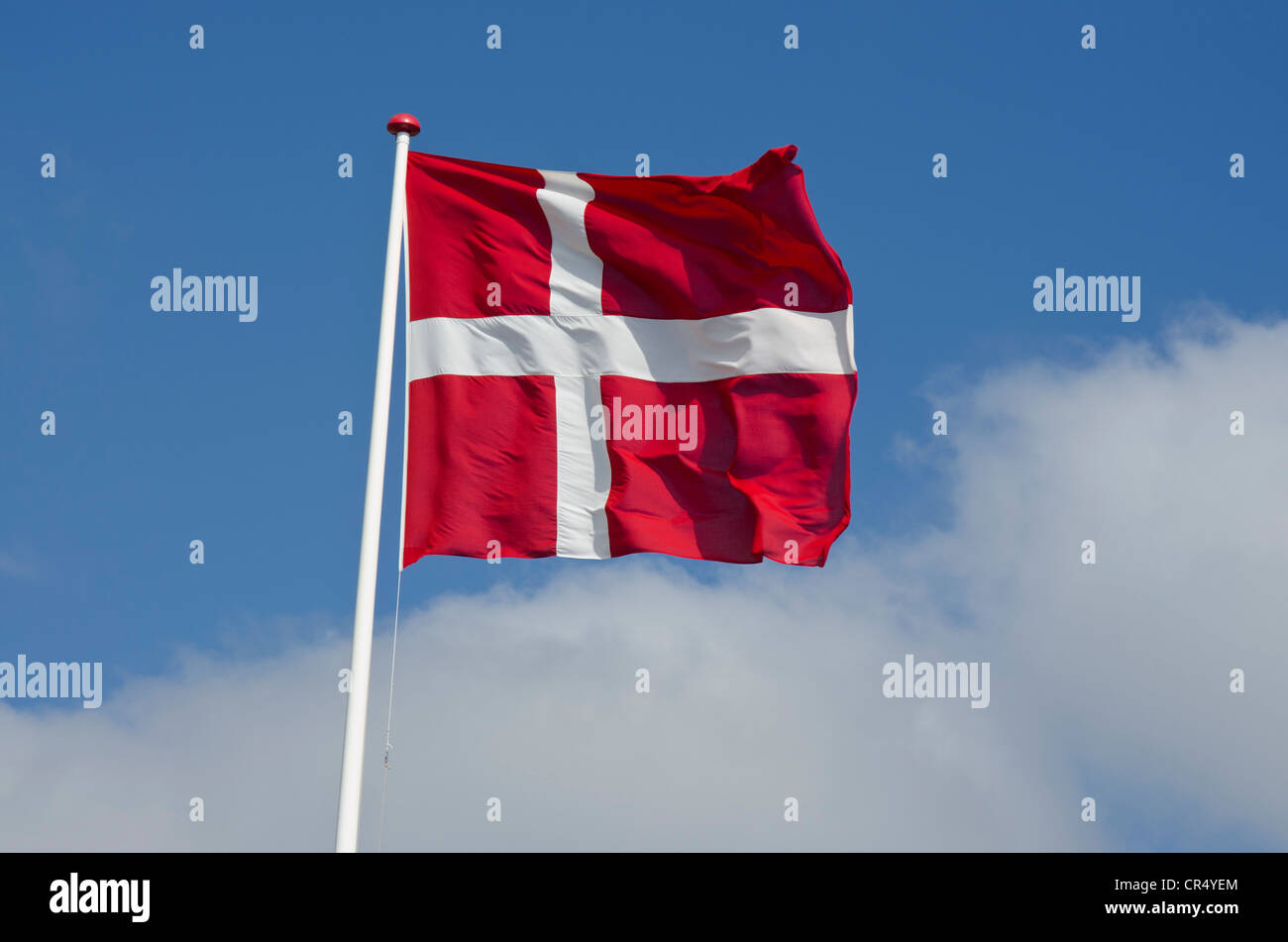 Danish national flag against a blue sky with clouds, Saeby, North Jutland region, Denmark, Europe Stock Photo
