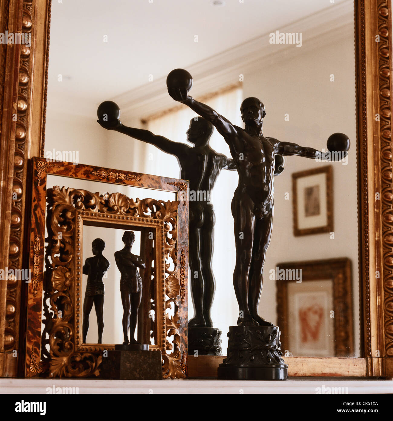 Art deco statue with carved picture frames and mirror Stock Photo