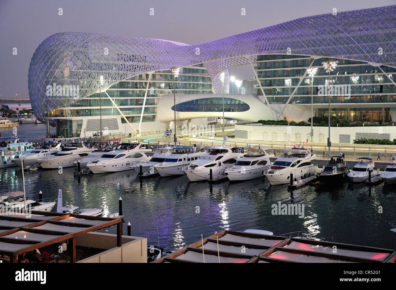 Yas Hotel and marina at the Formula One racetrack Yas Marina Circuit on Yas Island in the last daylight, Abu Dhabi Stock Photo