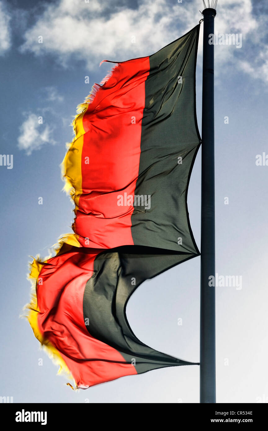 Tattered German flag flying in the wind, symbolic image for debt crisis Stock Photo