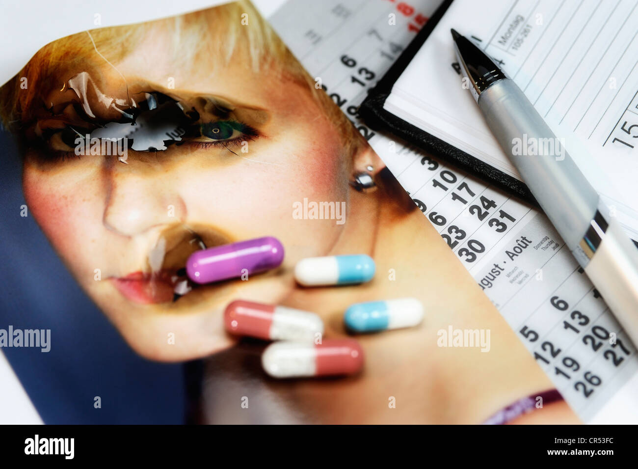 Singed photo and capsules, calendar and pen, symbolic image for burnout syndrome Stock Photo