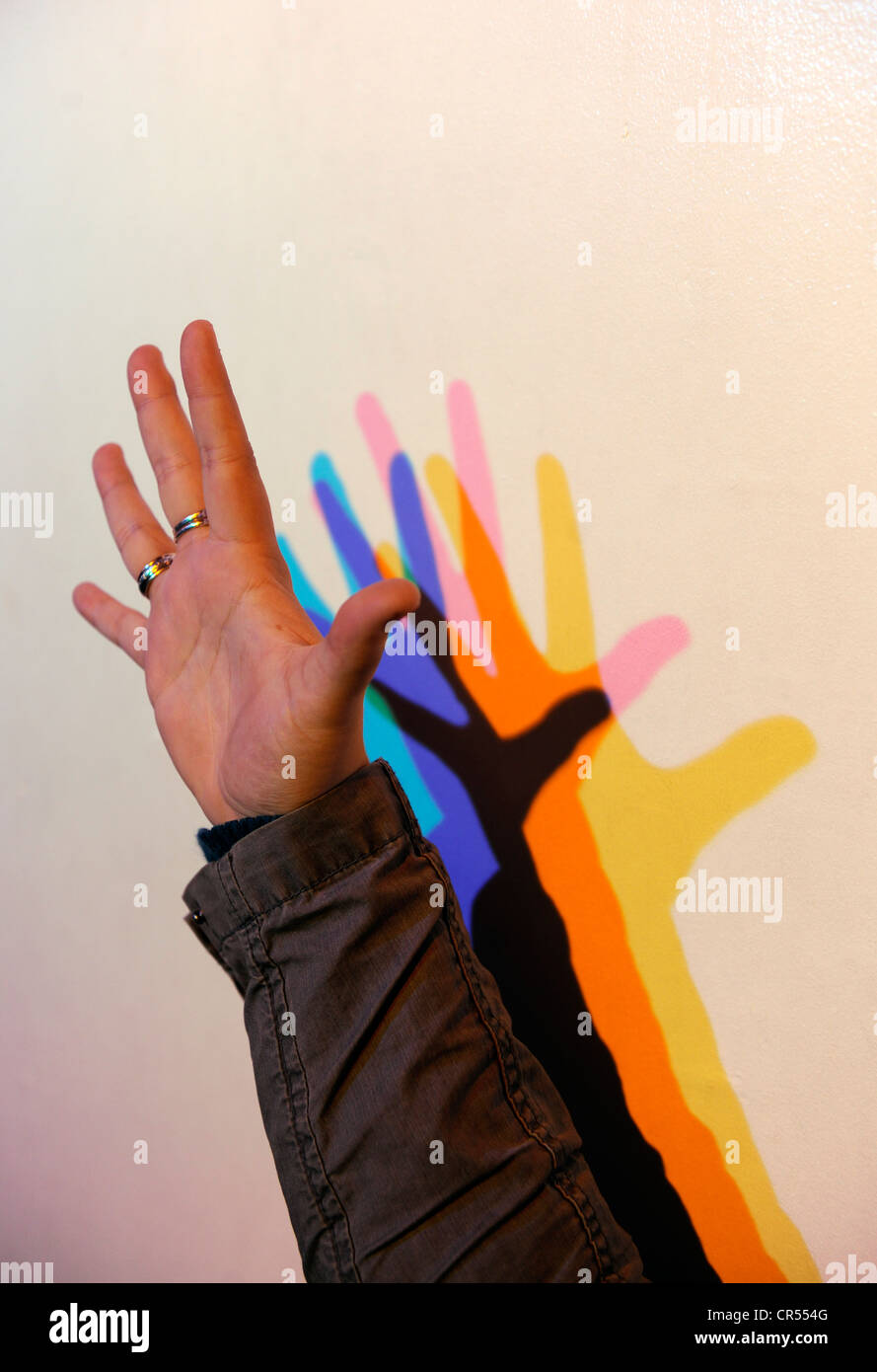 Hand Held In Front Of Red Green And Blue Lights Against A White