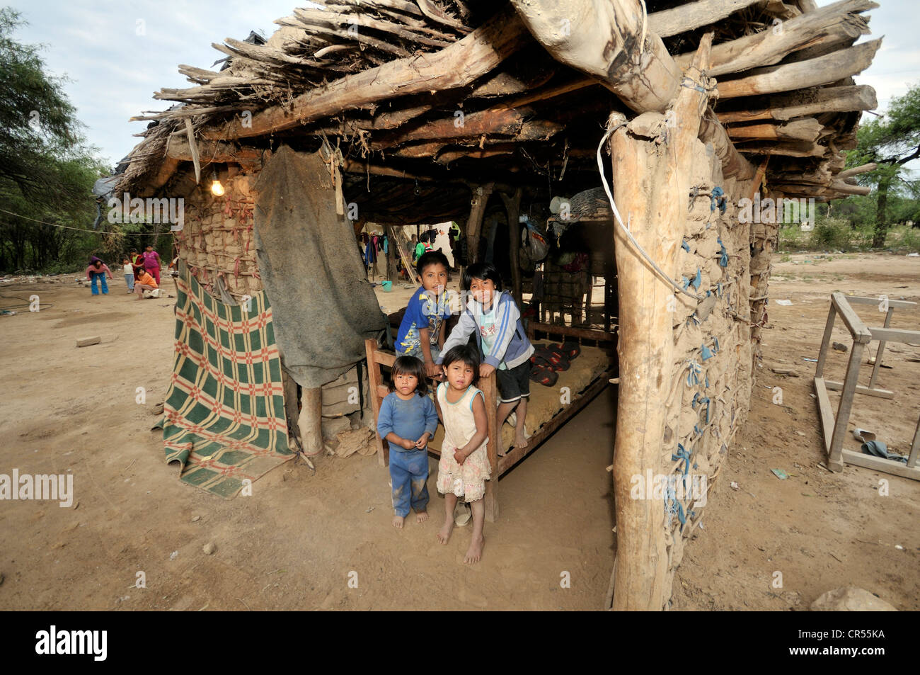 Indigenous children from the Wichi Indians tribe in a simple hut made of wood and clay, La Curvita, Gran Chaco, , Argentina Stock Photo