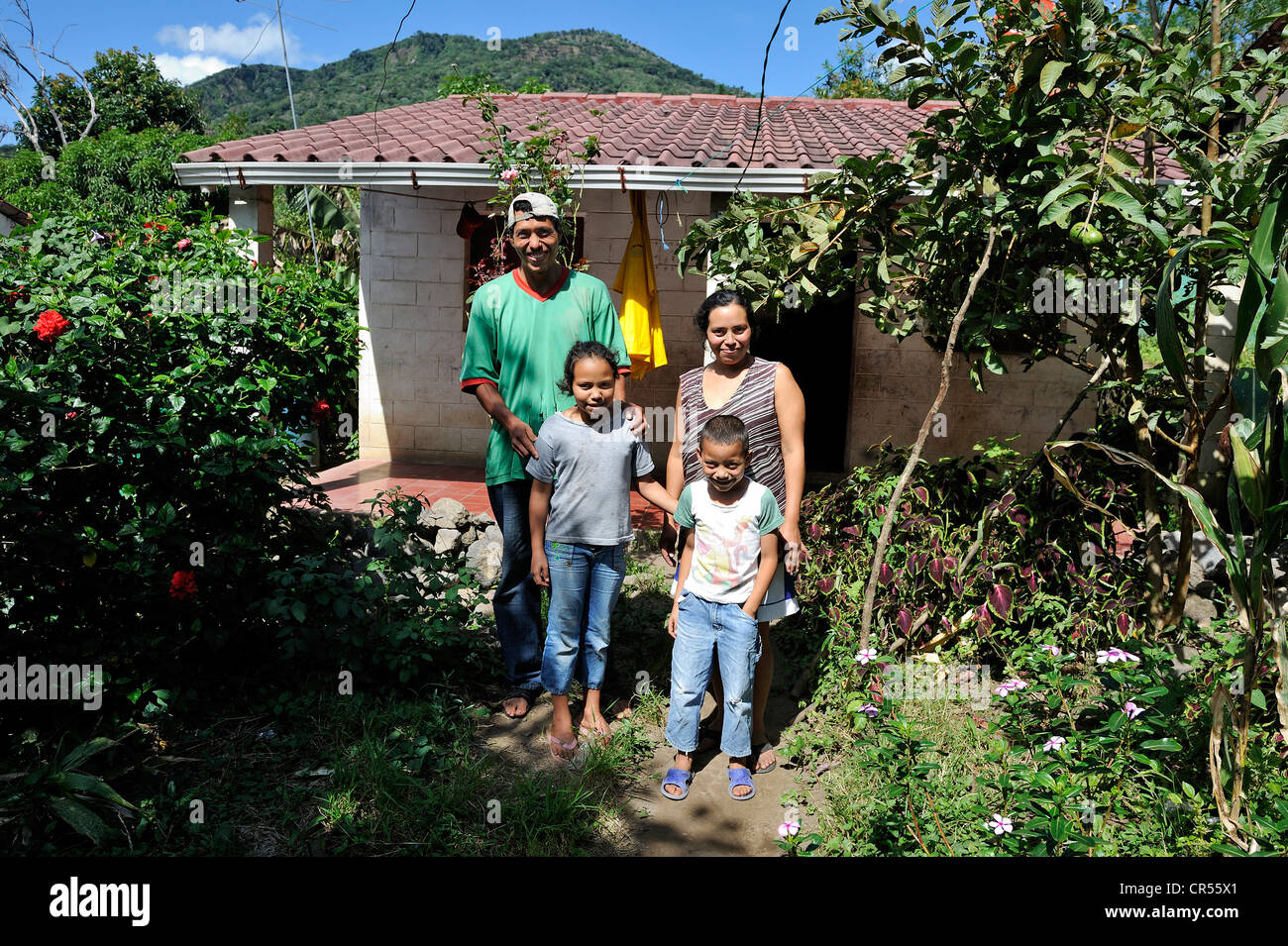 Family with two children in front of their house that was made available to them by an aid organisation after the 2011 Stock Photo