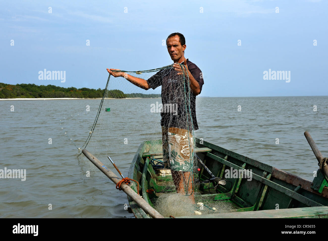 Fisherman in a small boat with a net in Sepitiba Bay, since the construction of the TKCSA steel plant by Thyssen-Krupp, the Stock Photo