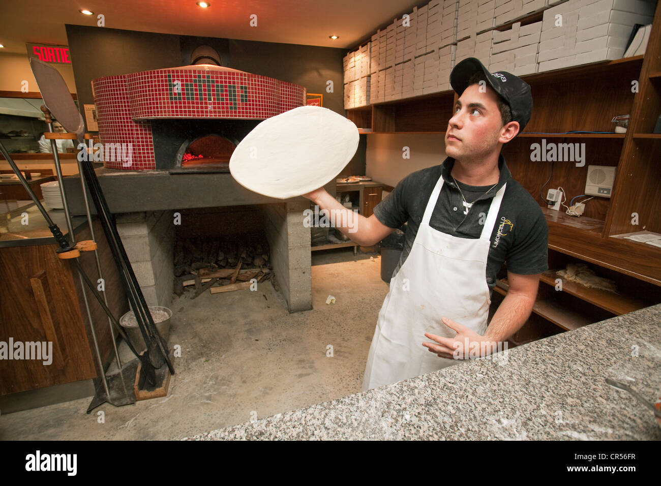 Canada Quebec Province Montreal Little Italy District Bottega Pizzeria pizzaiolo making his pizza in front of the baking oven Stock Photo