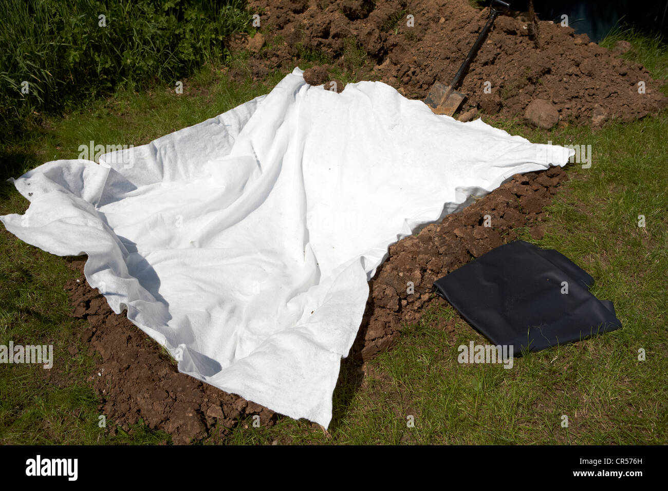 fleece lining a hole dug to build a pond in a garden in the uk w Stock Photo