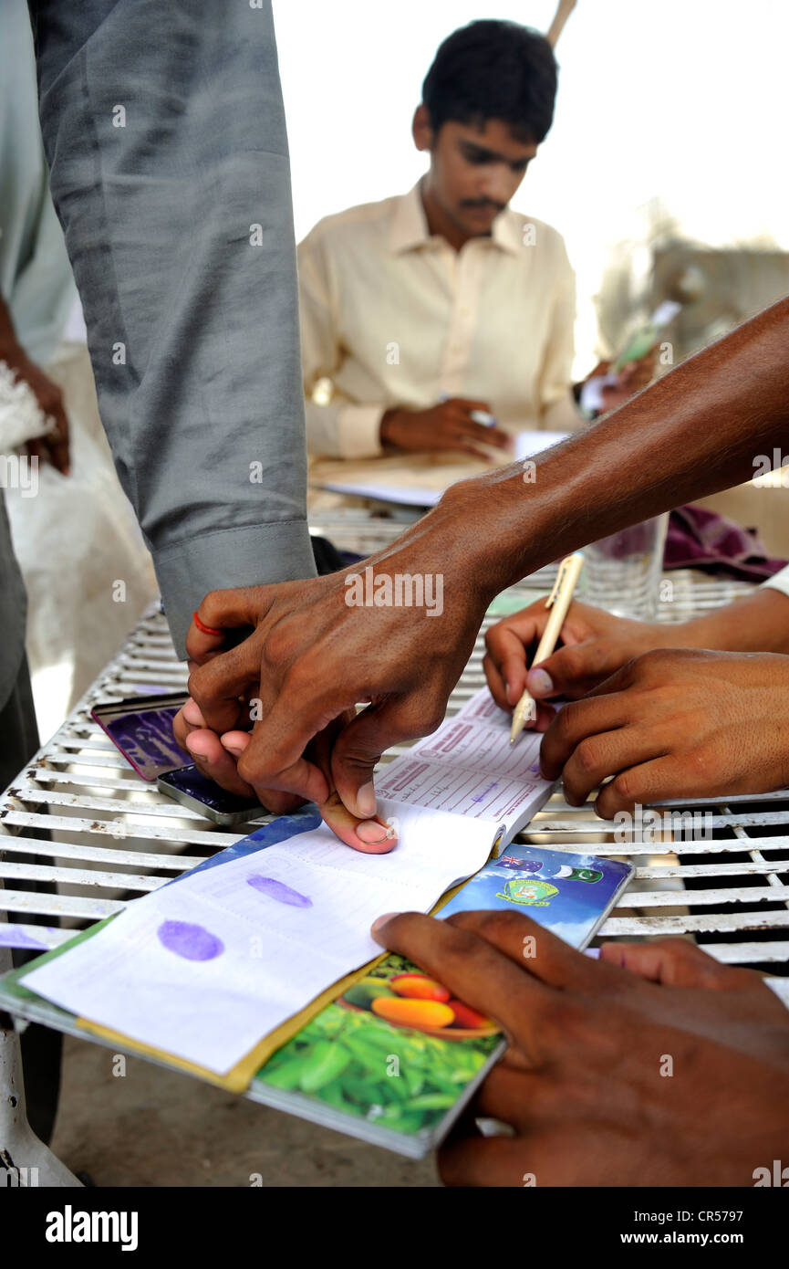 Distribution by a charity organisation after the flood disaster in 2010, beneficiaries signing with their fingerprint, Stock Photo