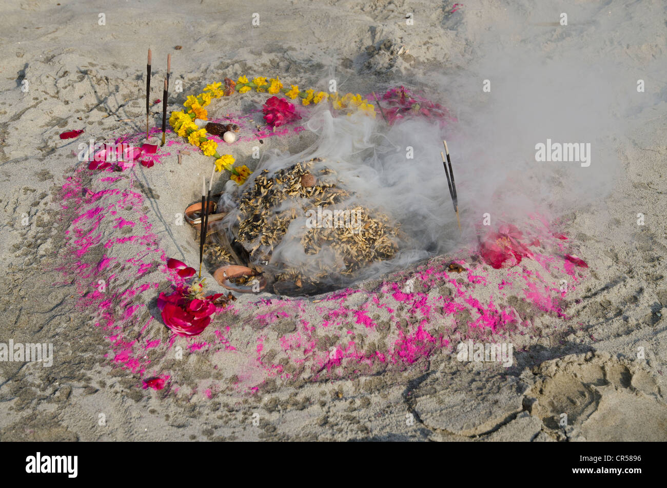 Burning incense; fire is often part of Sadhu reciting from the holy