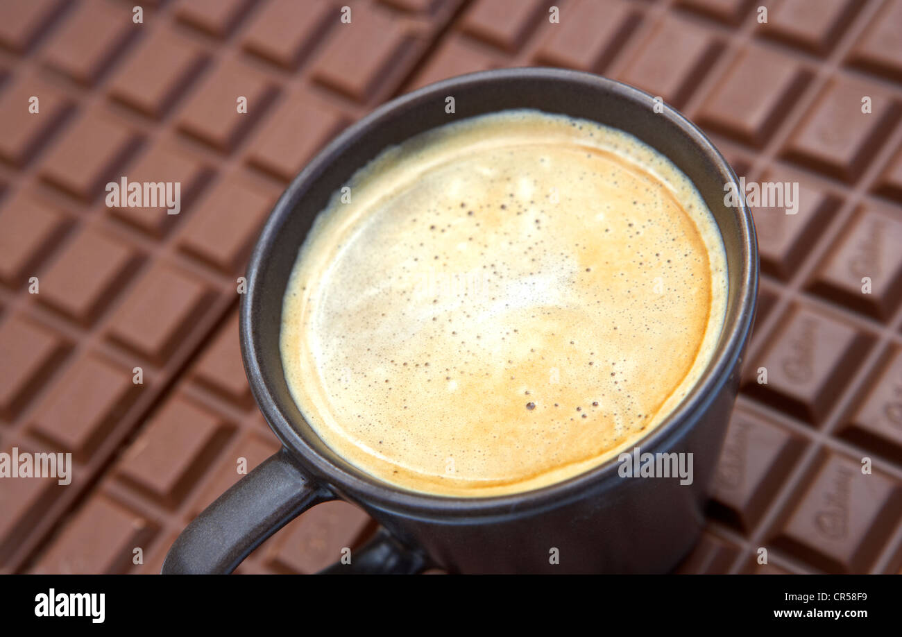 cup of coffee sitting on a slab of chocolate Stock Photo