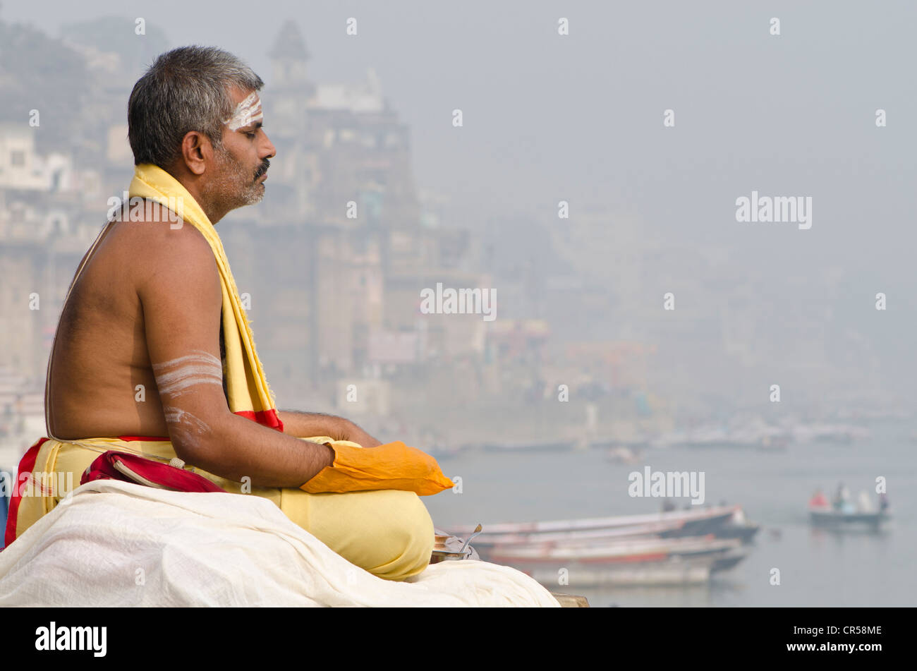 Brahmin man meditating at the holy river Ganges in the morning, Varanasi, Uttar Pradesh, India, Asia Stock Photo