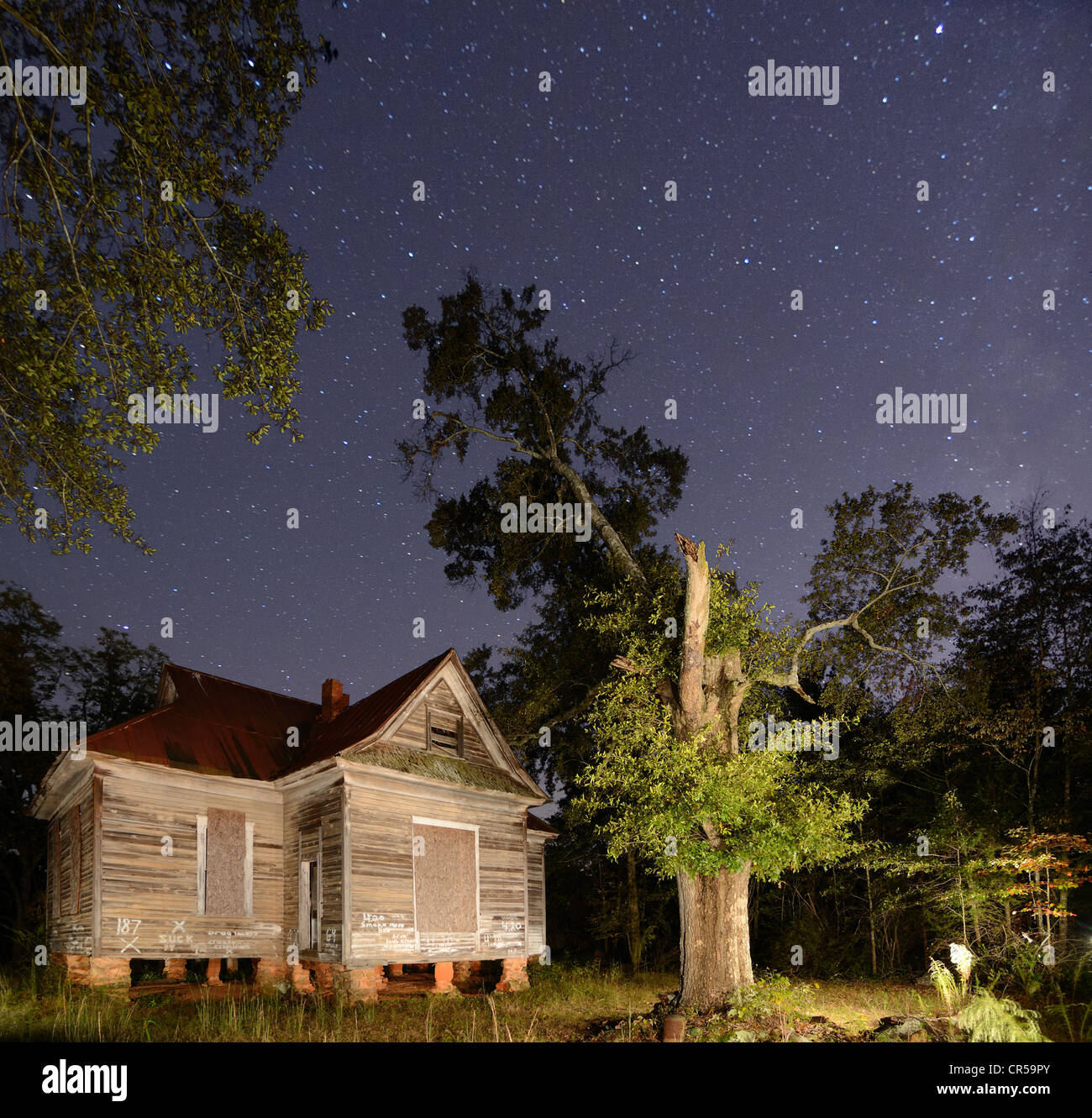 A scary abandoned house under a starry sky Stock Photo