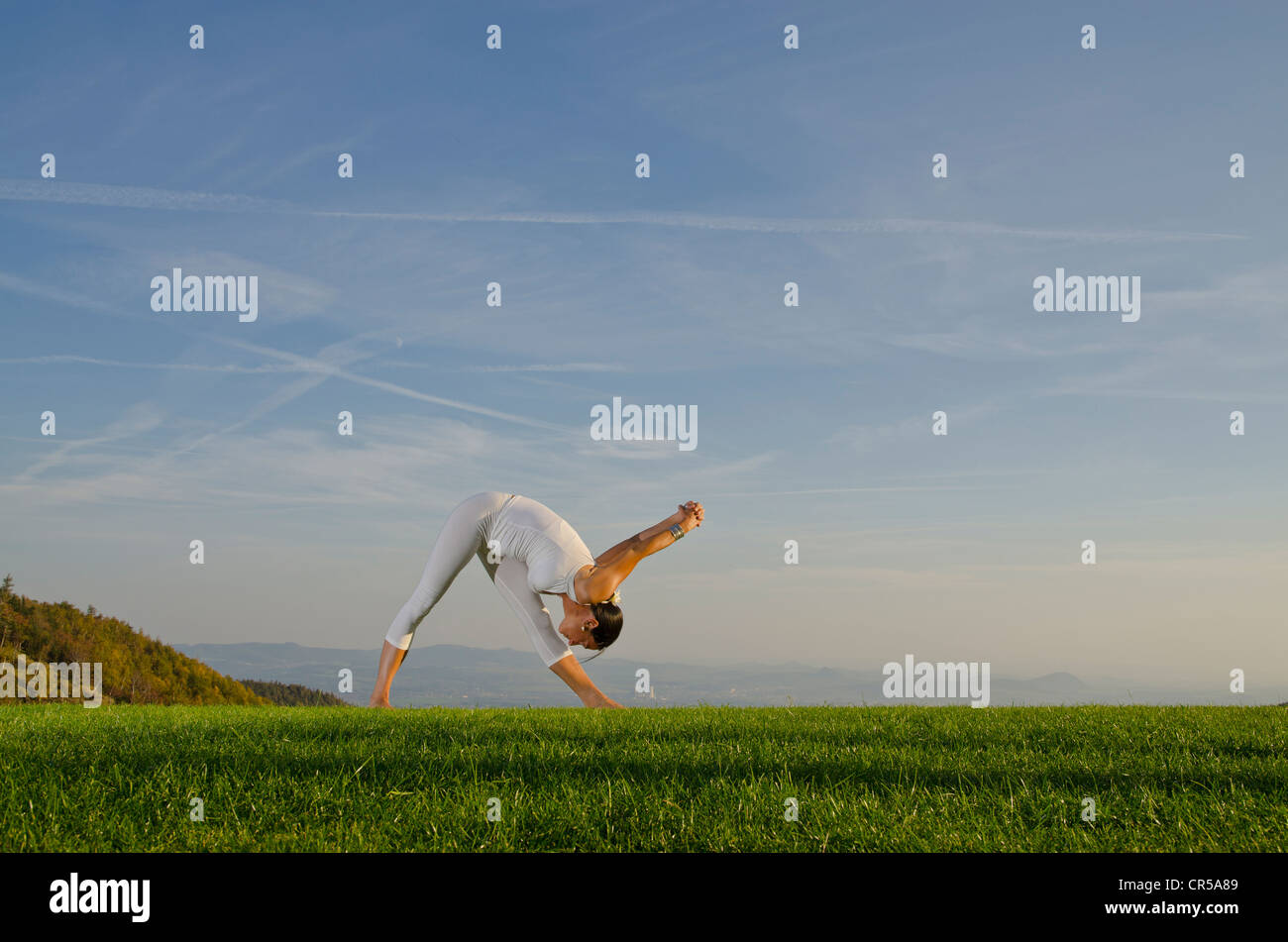 Young woman practising Hatha yoga outdoors, showing the pose parshvottanasana, sidestrech, , Czech Republic, Europe Stock Photo