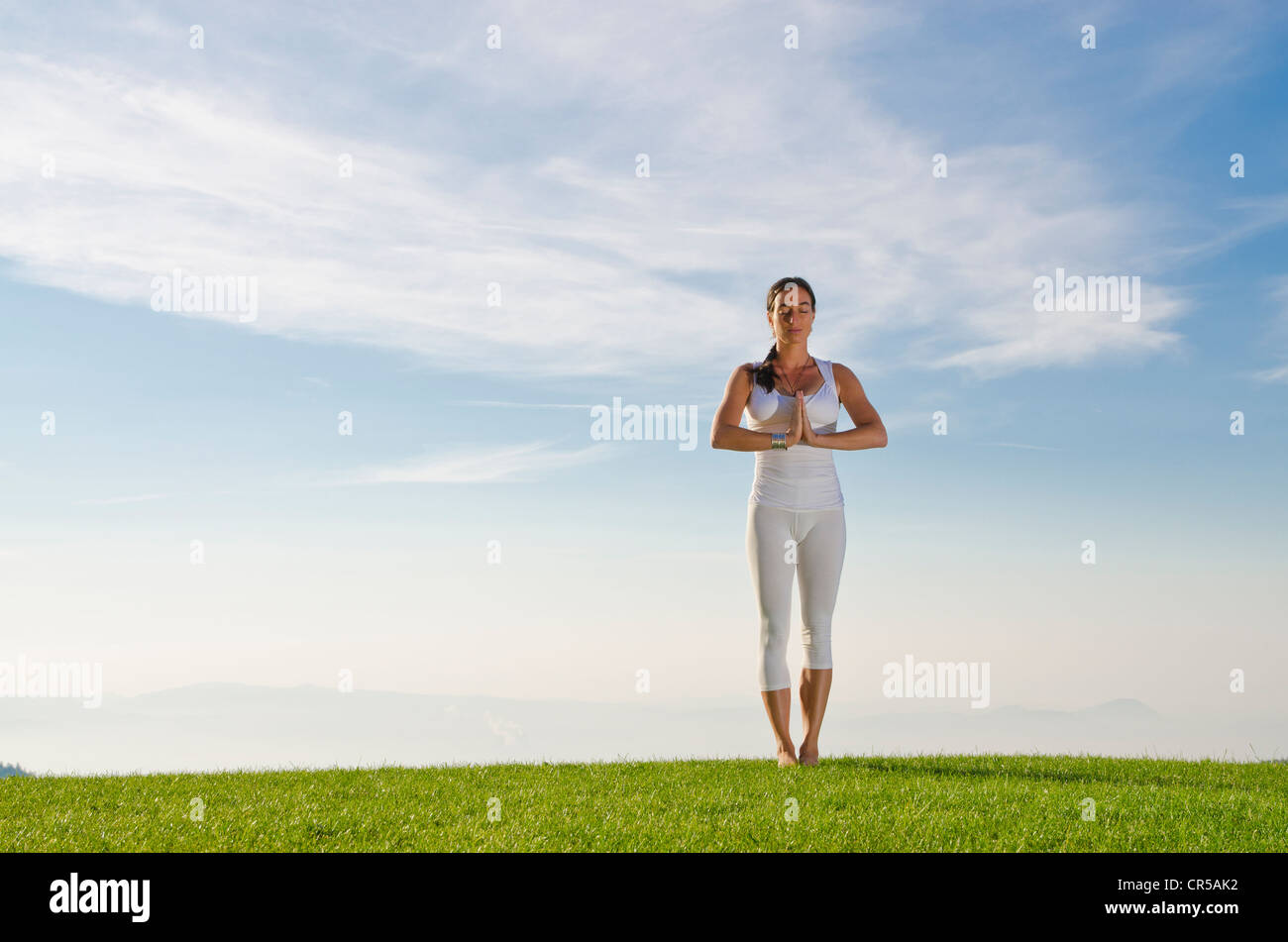 Young woman practising Hatha yoga outdoors, showing the pose tadasana, pranamasana, prayer pose, , Czech Republic, Europe Stock Photo