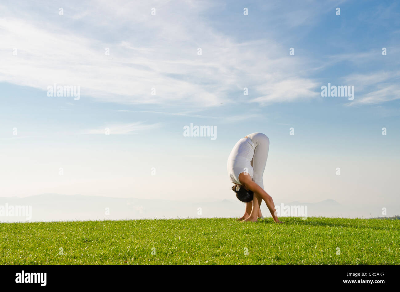 Young woman practising Hatha yoga outdoors, showing the pose uttanasana, forward bend, , Czech Republic, Europe Stock Photo