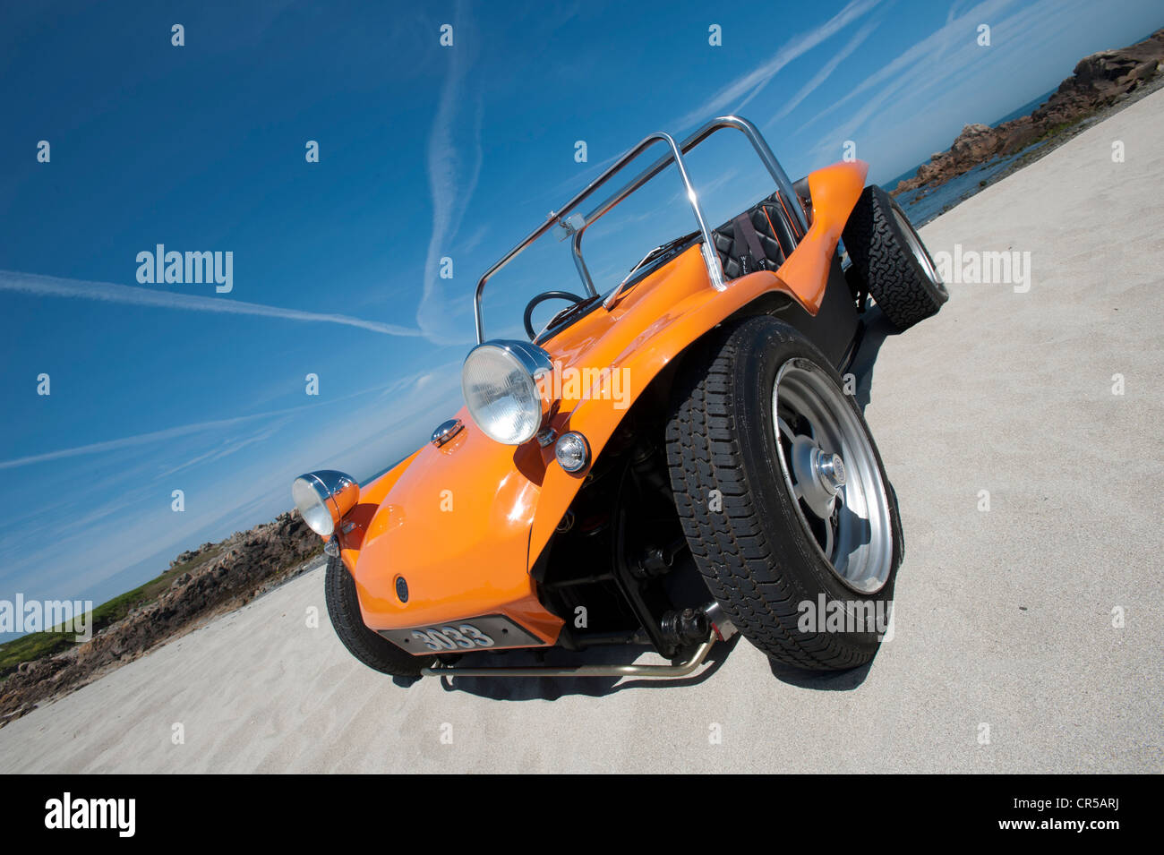 VW beach buggy on a sandy beach under a blue sky Stock Photo