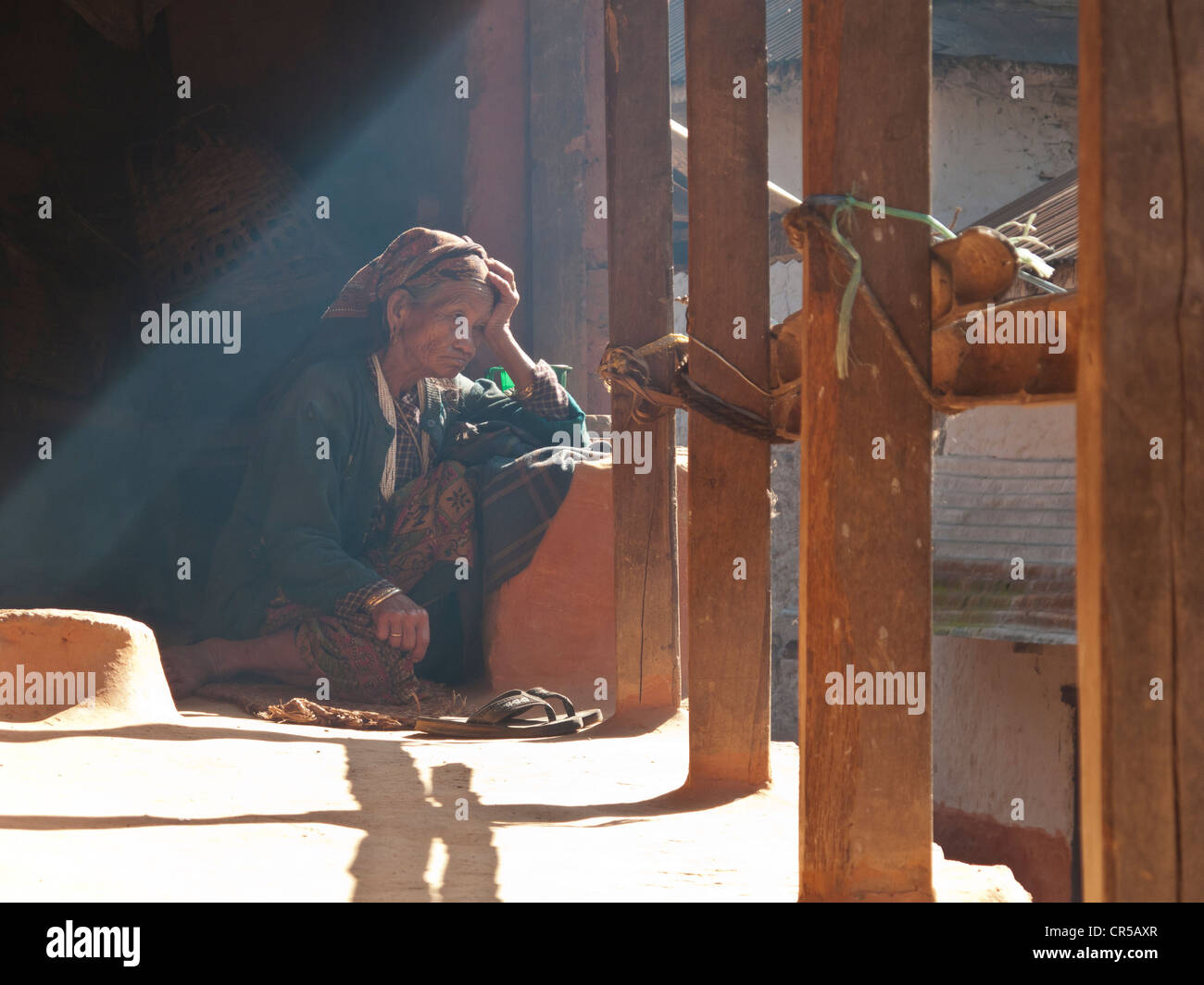 Old lady sitting on the terrace of her house, Chisapani, Helambu, Nepal, Asia Stock Photo
