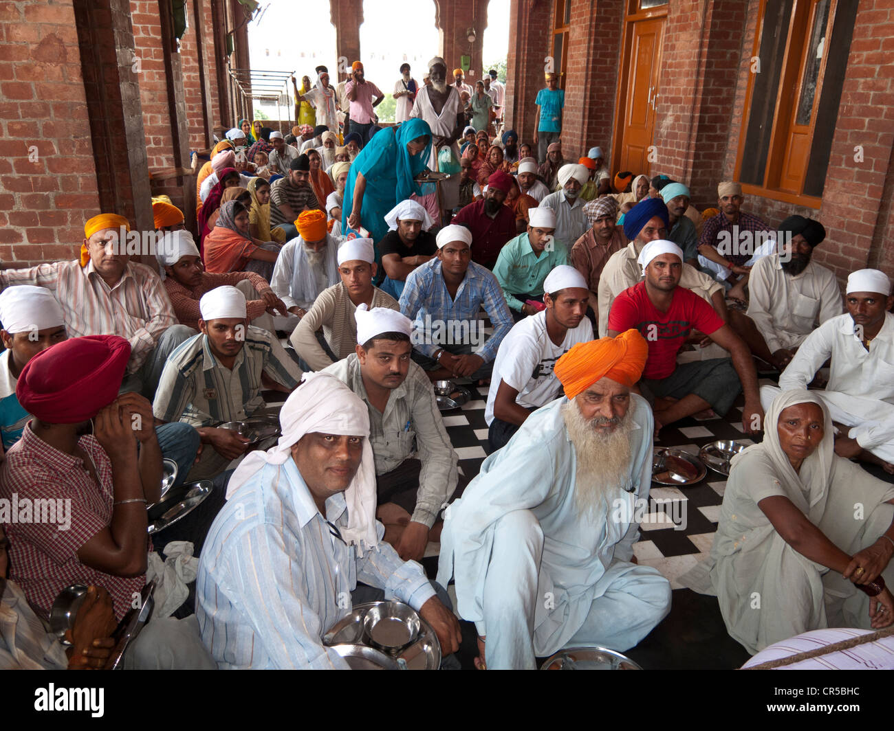 Hungry pilgrims waiting to be served food at the langar, or canteen, Amritsar, Punjab, India, Asia Stock Photo