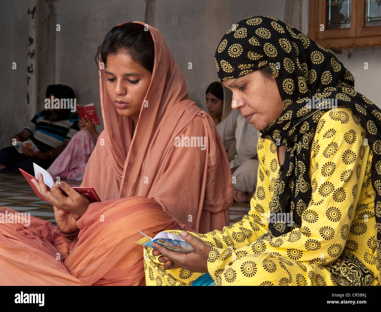 Two Sikh ladies reciting texts from the holy scriptures, Amritsar, Punjab, India, Asia Stock Photo