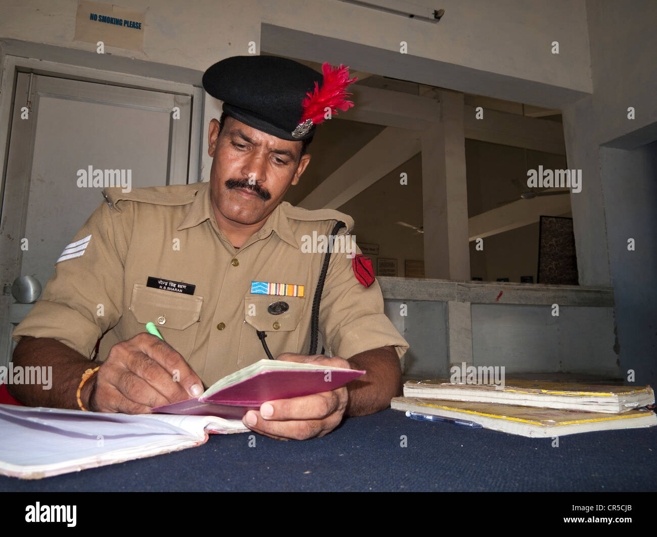 Indian security officer checking passport at border crossing, Wagah Border, Punjab, India, Asia Stock Photo