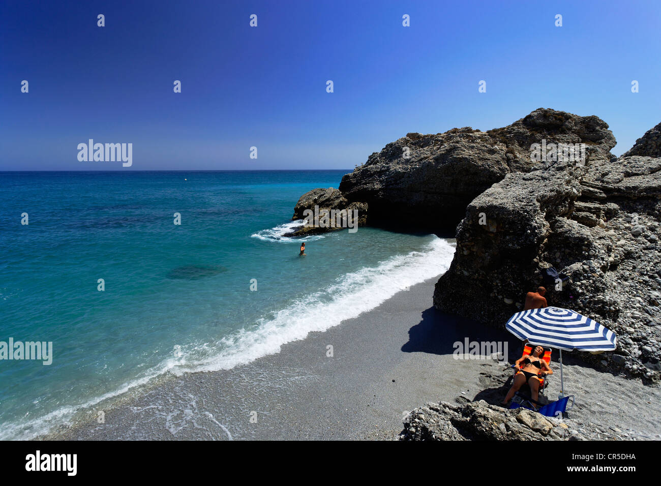 Spain, Andalusia, Costa del Sol, Nerja, woman sunbathing at Playa del Salon Beach Stock Photo
