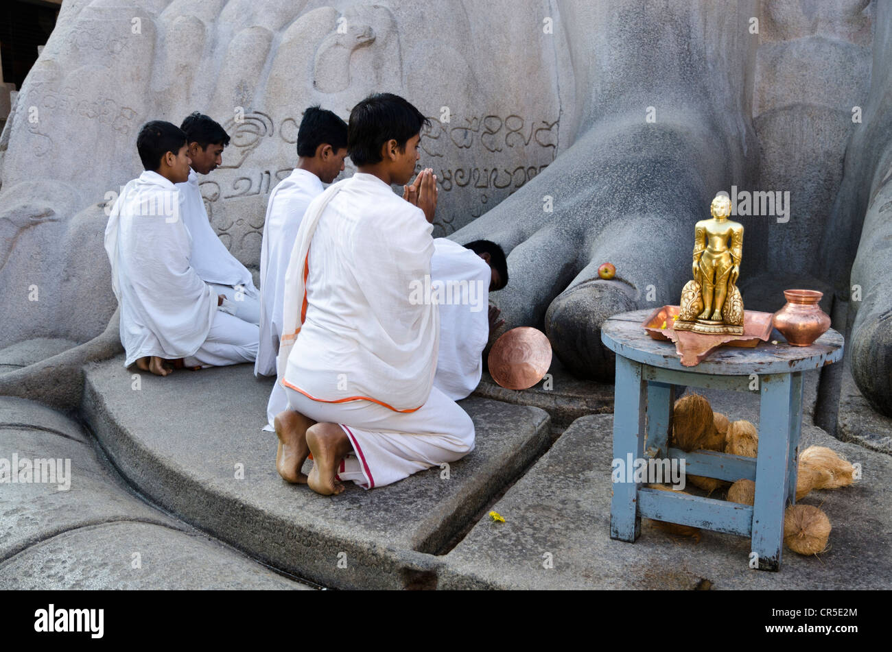 Jain pilgrims are praying at the feet of the gigantic statue of Gomateshwara in Sravanabelagola, Karnataka, India, Asia Stock Photo