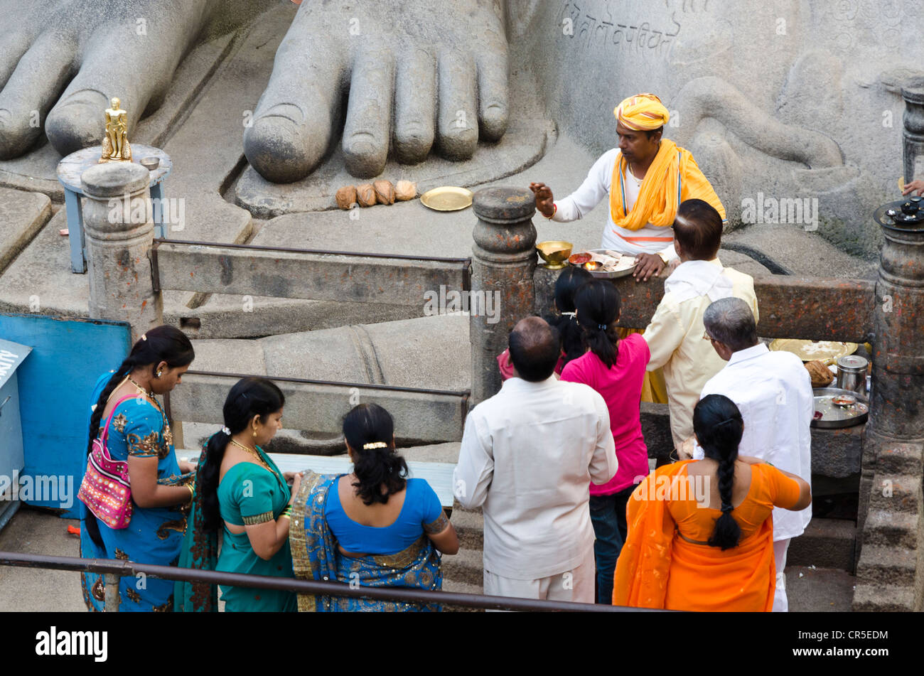 Pilgrims receive the blessings of Bahubali by a local priest on Indragiri hill in Sravanabelagola, Karnataka, India, Asia Stock Photo
