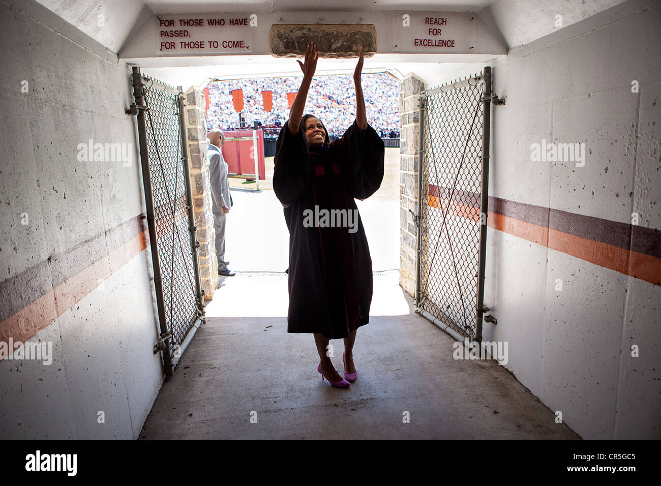 US First Lady Michelle Obama reaches up and touches the Hokie Stone before walking onto the field at Lane Stadium to give the Virginia Tech commencement address May 11, 2012 in Blacksburg, VA. Stock Photo