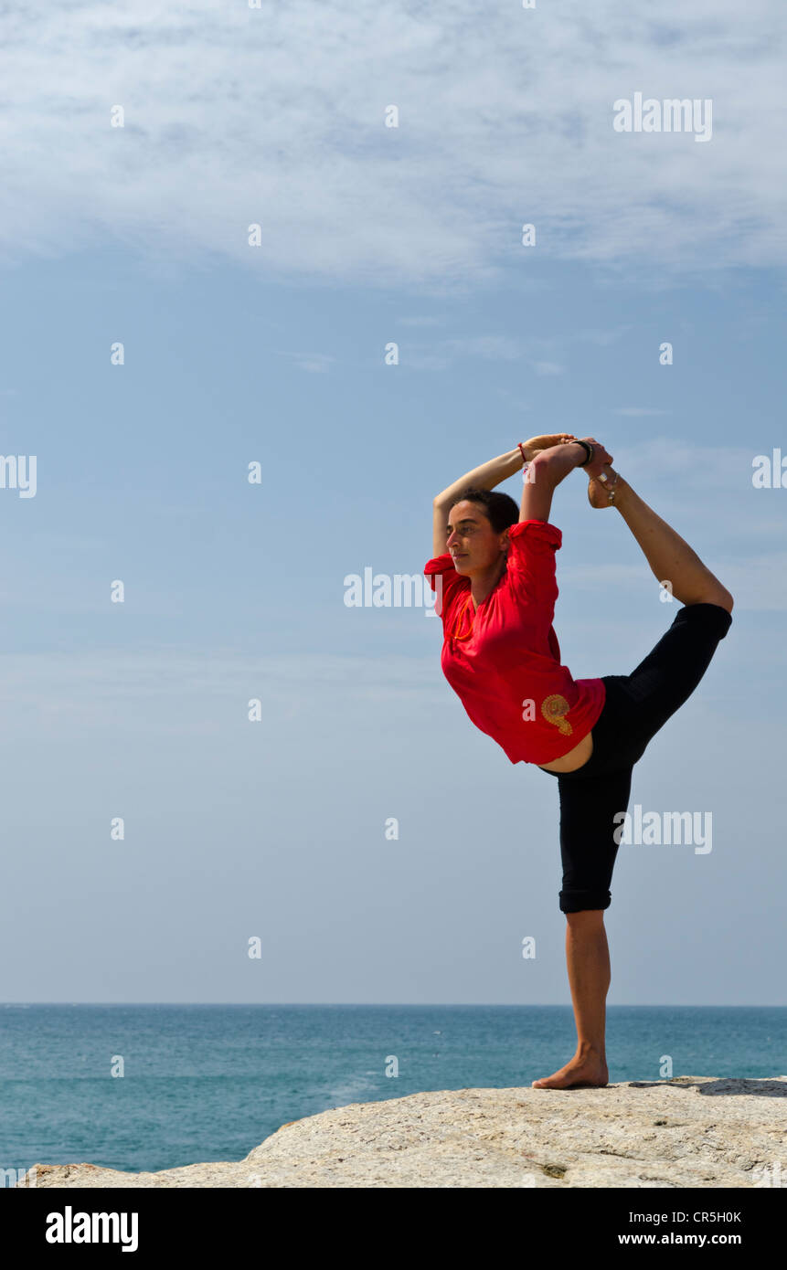 Woman in a yoga position, Natarajasana, by the sea in Kanyakumari, Tamil Nadu, India, Asia Stock Photo