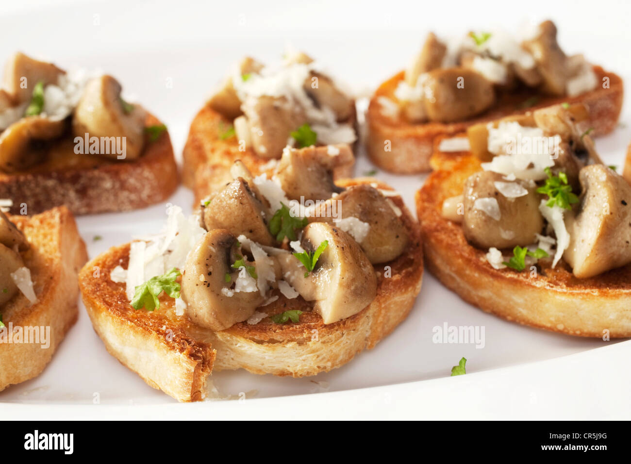 Italian finger food, bruschetta are topped with garlic and olive oil, mushrooms and Italian pecorino cheese. Stock Photo