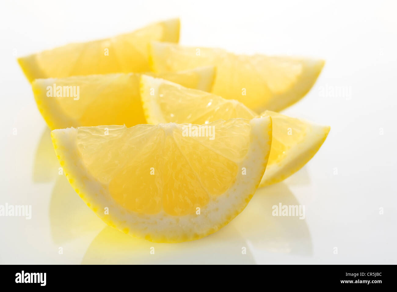 Lemon wedges, backlit on a white plate. Stock Photo