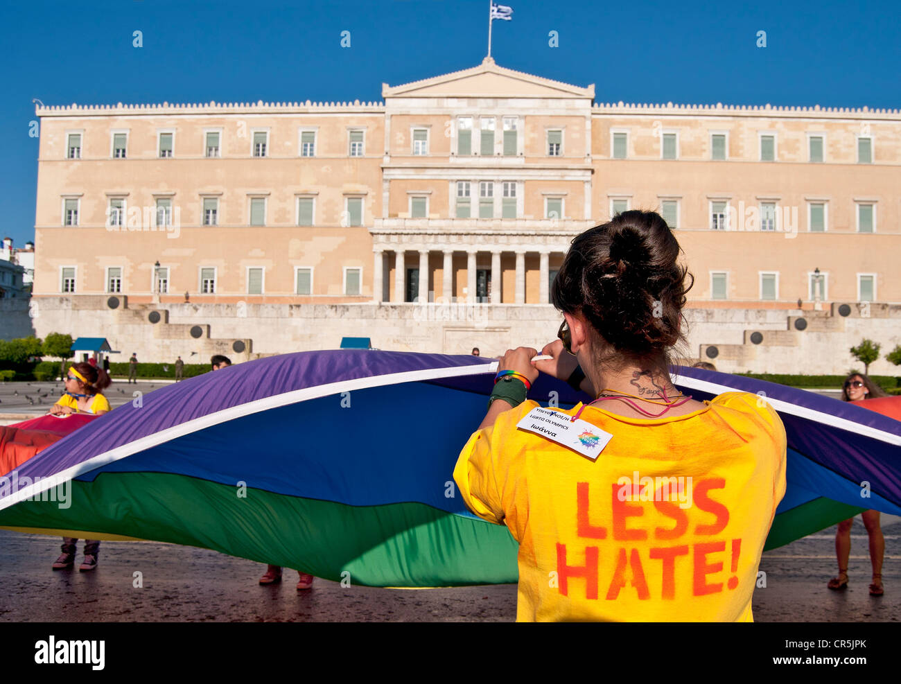 Athens pride- gay parade in front of the greek parliament. Volunteer girl carrying the rainbow flag Stock Photo
