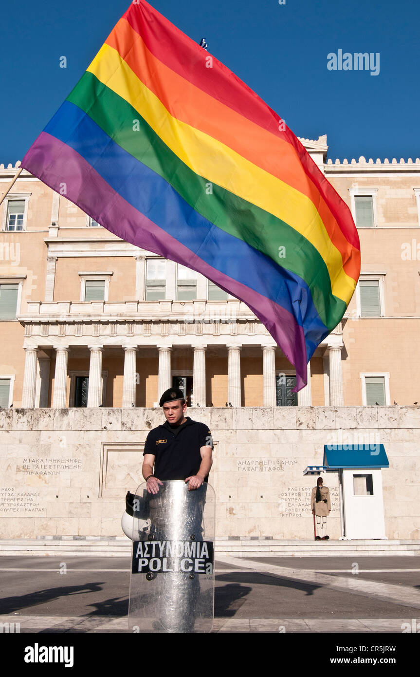 The gay rainbow flag above the head of policeman in front of the parliament- Athens, Greece, the gay parade 'Athens pride' 2012 Stock Photo