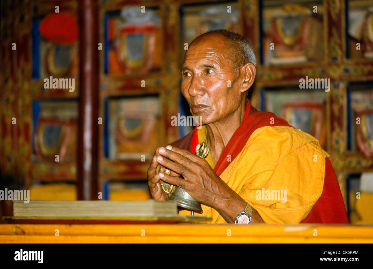 Buddhist monk praying in front of the library, Thiksey, Jammu and Kashmir, India, Asia Stock Photo