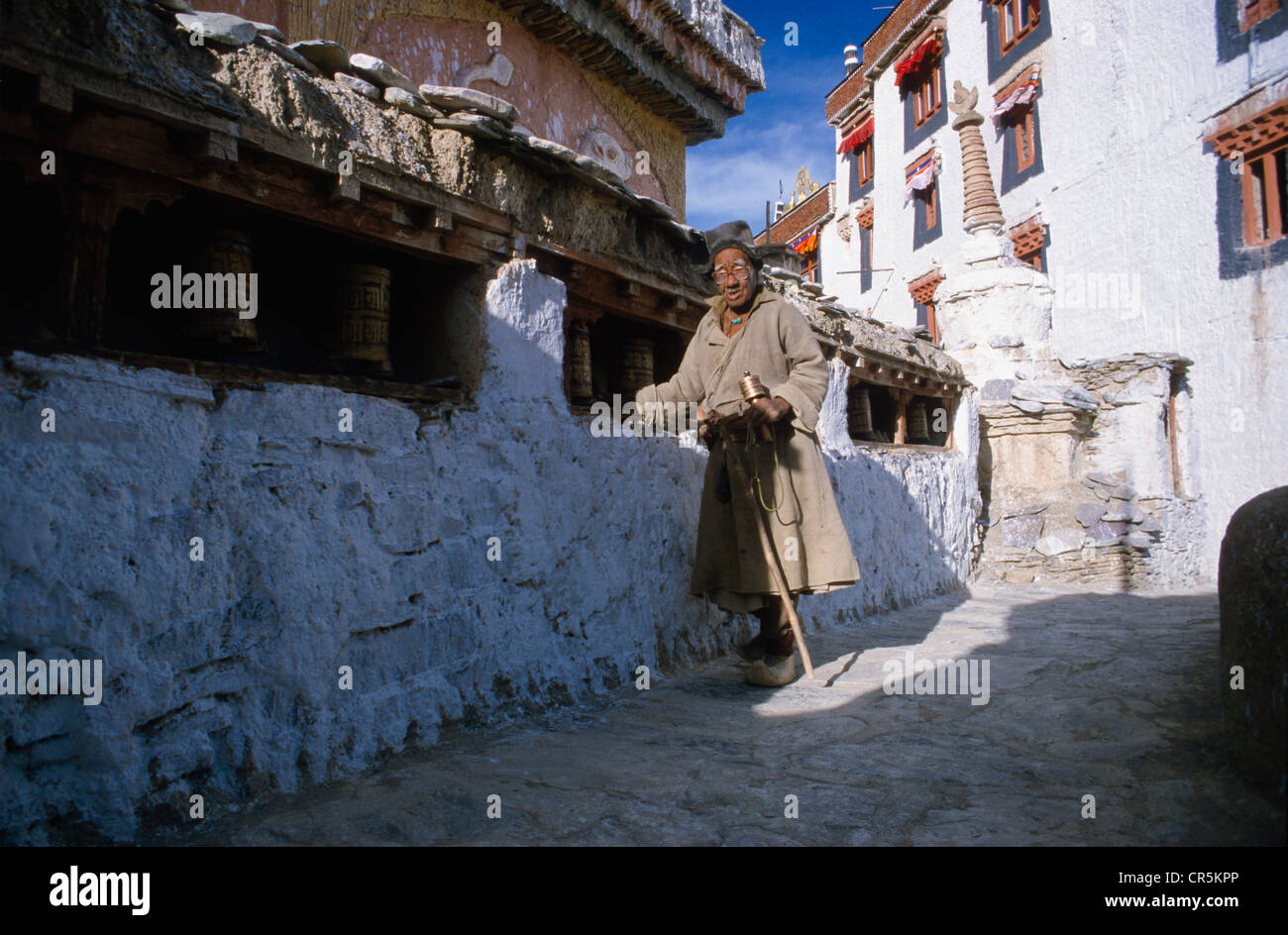 Old man turning prayer wheels in Lamayuru Gompa, Jammu and Kashmir, India, Asia Stock Photo