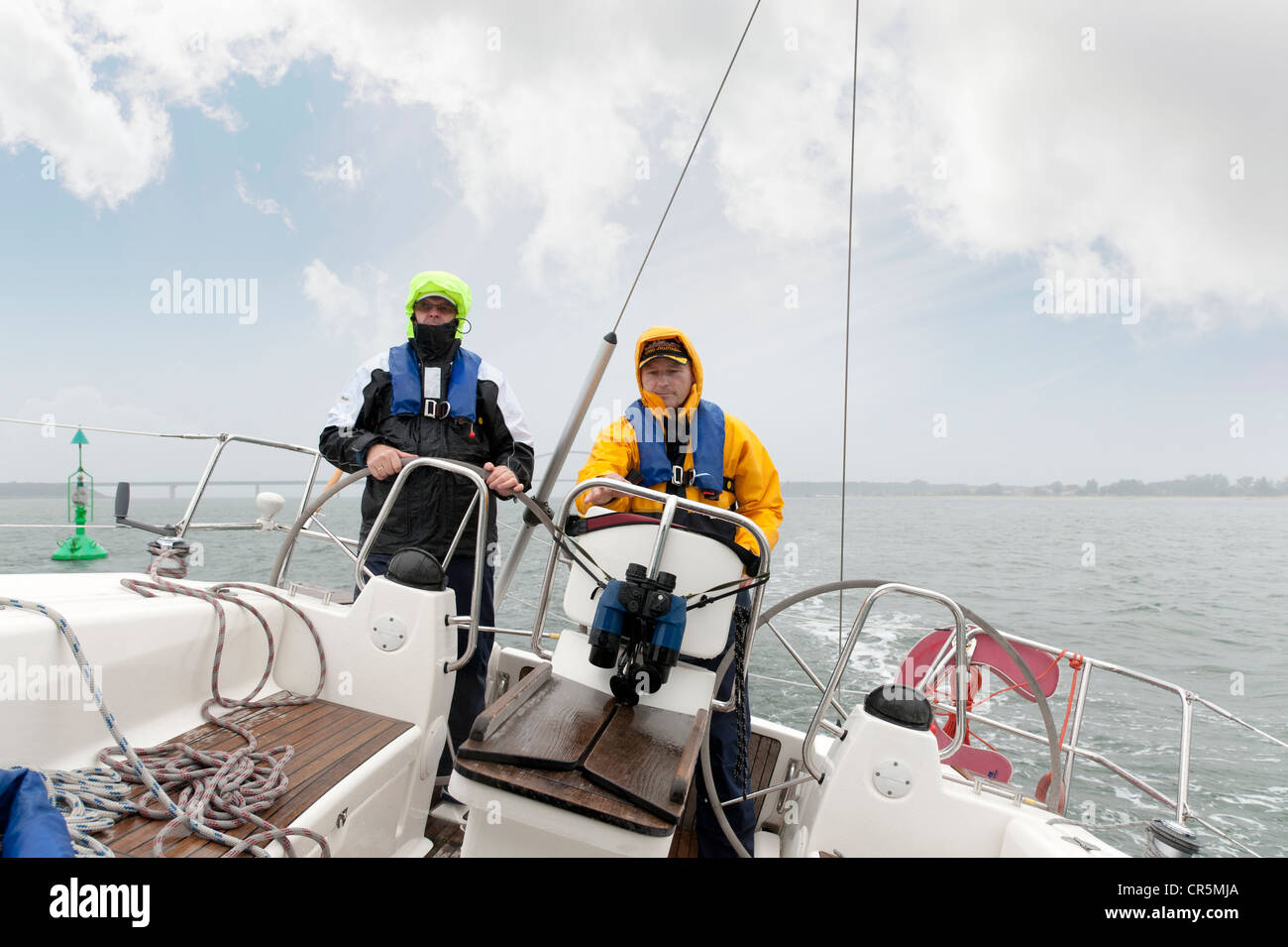 Two sailors standing at the stern of a yacht Stock Photo