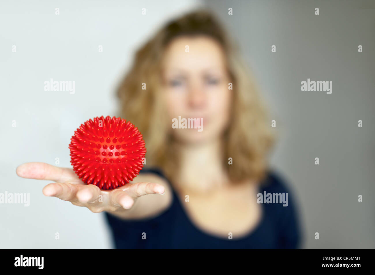 Young woman holding a spiky massage ball in her outstretched hand Stock ...